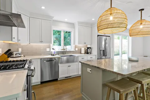 a kitchen with stainless steel appliances granite countertop a sink a stove and a refrigerator