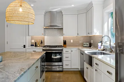 a kitchen with stainless steel appliances granite countertop a sink a stove and a microwave