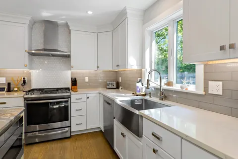 a kitchen with stainless steel appliances white cabinets and a sink