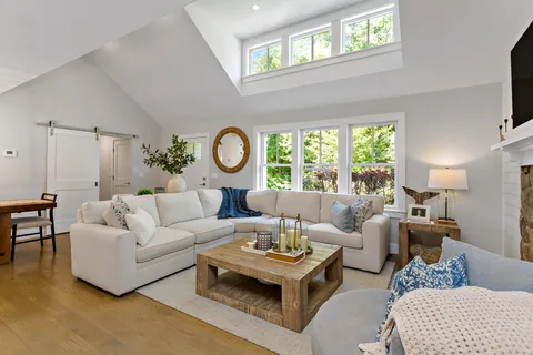 a living room with furniture a rug and a window