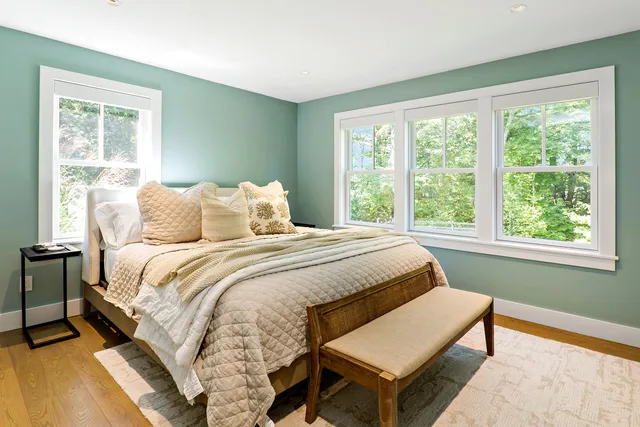 a bedroom with a bed a window and a lamp