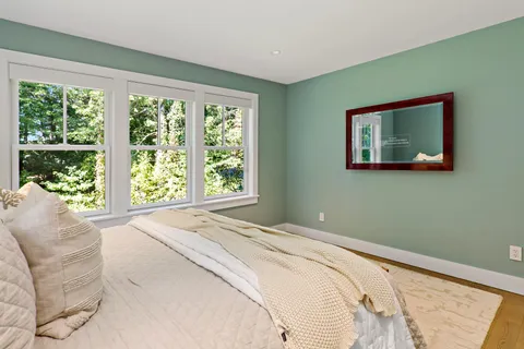 a bedroom with a bed and a large window