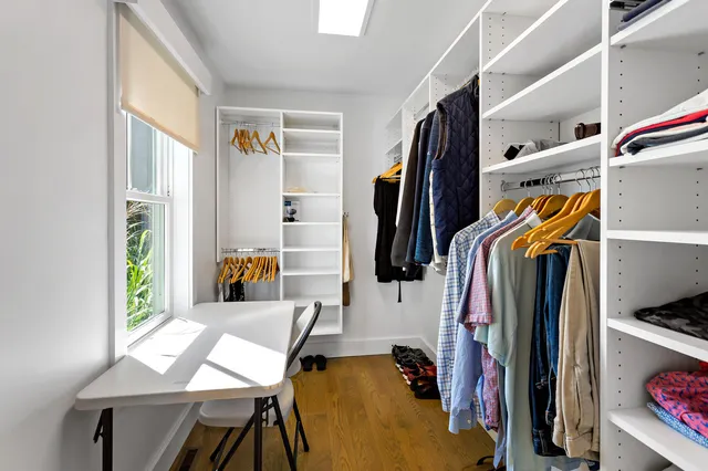 a view of walk in closet with clothes and shoes
