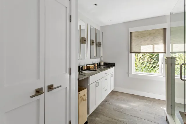 a kitchen with granite countertop white cabinets and window