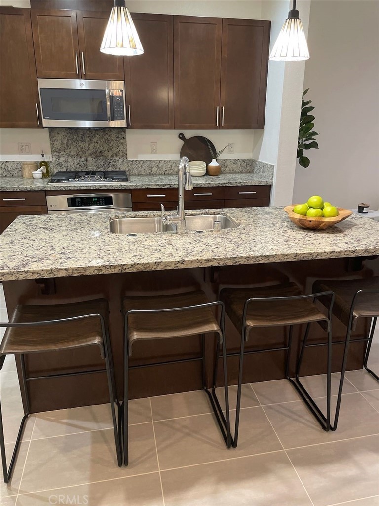 37 Soho Irvine, CA 92612 - Photo 8 of 21 a kitchen with granite countertop a sink a stove and cabinets
