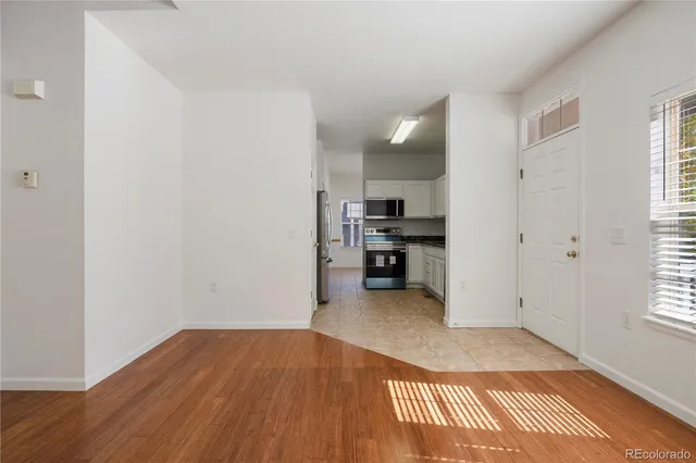 a view of empty room with wooden floor and windows