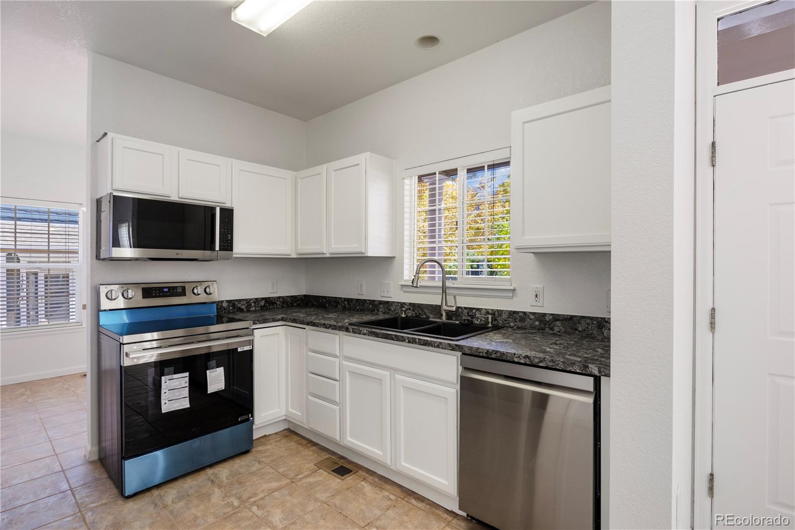 1480 Thunder Butte Road Castle Rock, CO 80109 - Photo 20 of 35 a kitchen with granite countertop a sink stove top oven and microwave