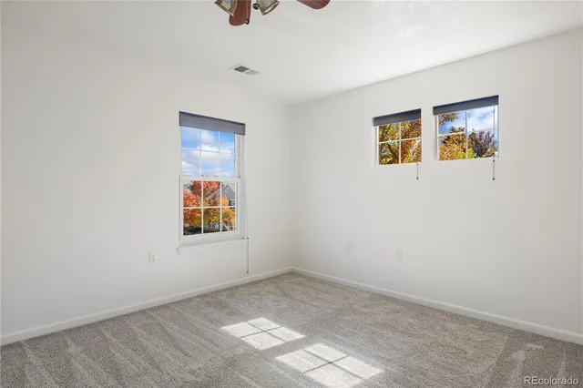 an empty room with windows and painted walls