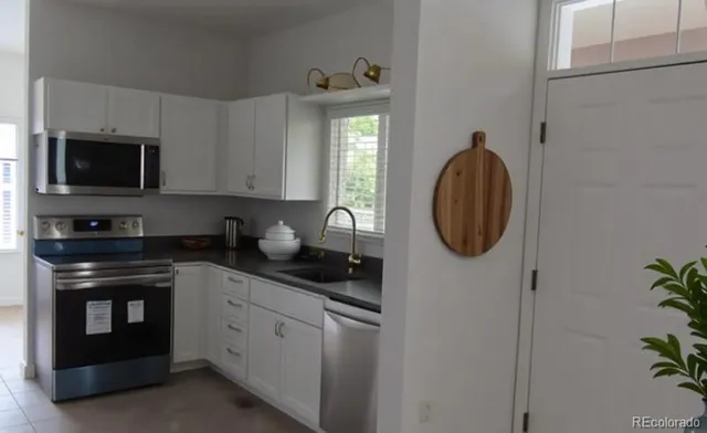 a kitchen with stainless steel appliances granite countertop a stove a sink and a microwave