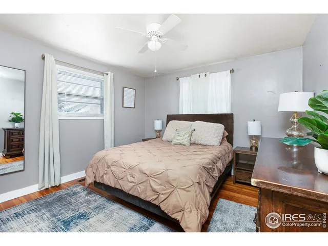 a bedroom with a bed window and wooden floor
