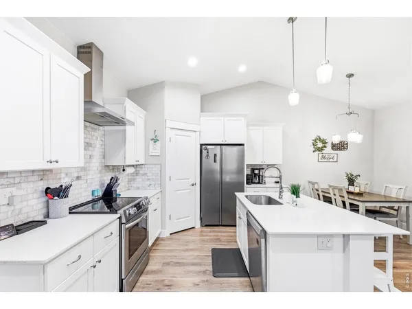 a kitchen with stainless steel appliances kitchen island granite countertop a sink stove and refrigerator