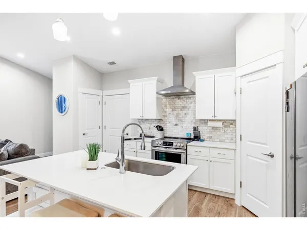 a kitchen with a white wooden cabinets and white appliances
