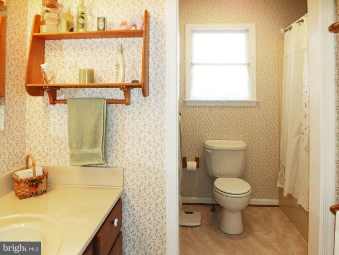 18607 Brick Store Road Hampstead, MD 21074 - Photo 22 of 30 a bathroom with a granite countertop sink toilet and mirror