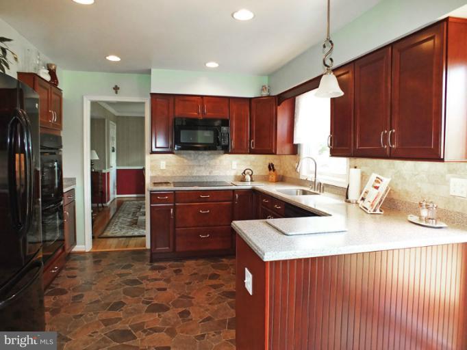 18607 Brick Store Road Hampstead, MD 21074 - Photo 6 of 30 a kitchen with a sink a stove and a refrigerator