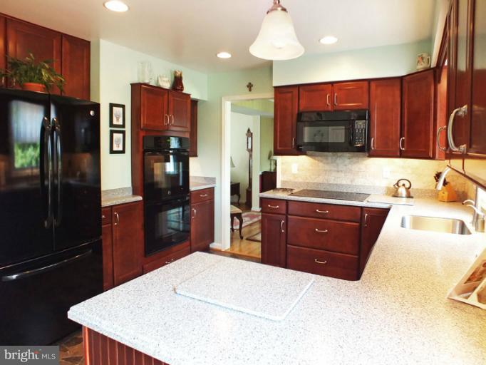 18607 Brick Store Road Hampstead, MD 21074 - Photo 7 of 30 a kitchen with stainless steel appliances kitchen island granite countertop a refrigerator and a wooden cabinets