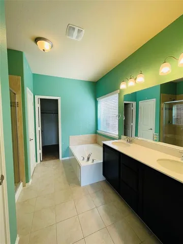 a large bathroom with a large tub and sink