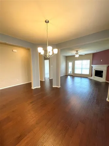a view of a room with wooden floor chandelier and entryway