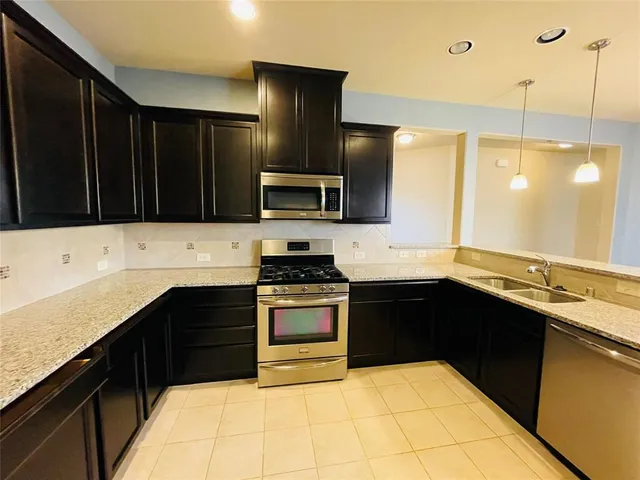 a kitchen with a sink stove and microwave