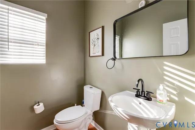 a bathroom with a sink mirror and toilet