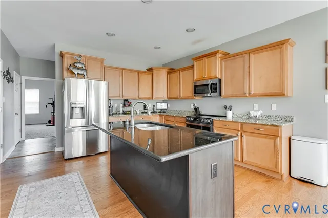 a kitchen with stainless steel appliances granite countertop a refrigerator a stove top oven a sink and dishwasher