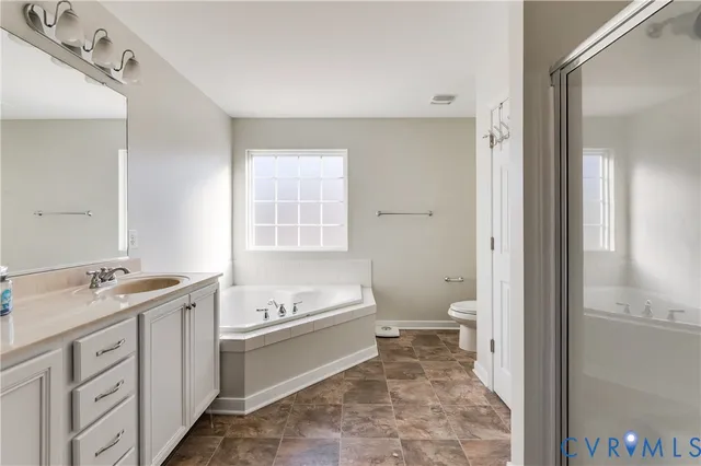 a spacious bathroom with a granite countertop sink a toilet and a mirror