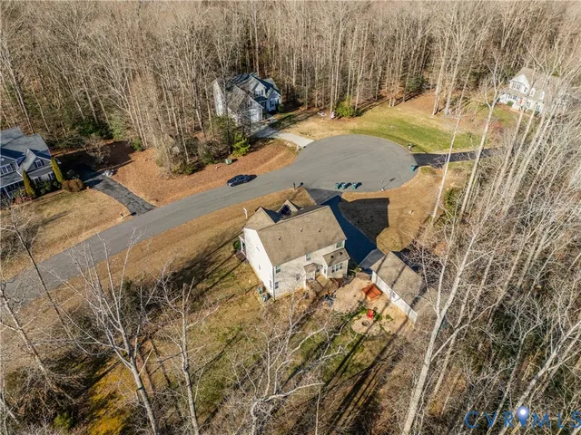a view of house with backyard and trees in the background