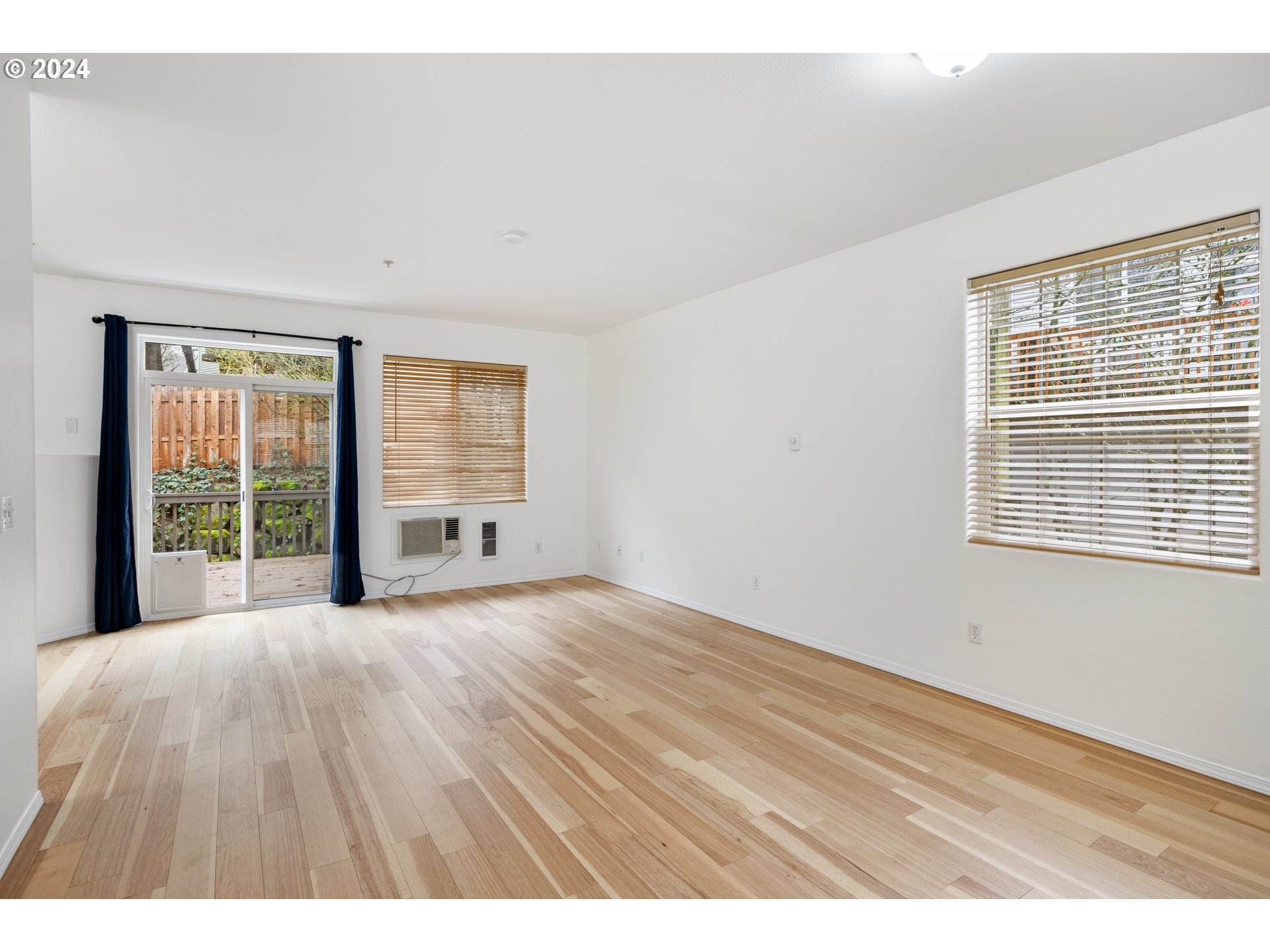 14340 Southwest Cougar Ridge Drive Beaverton, OR 97008 - Photo 13 of 37 a view of an empty room with wooden floor and windows