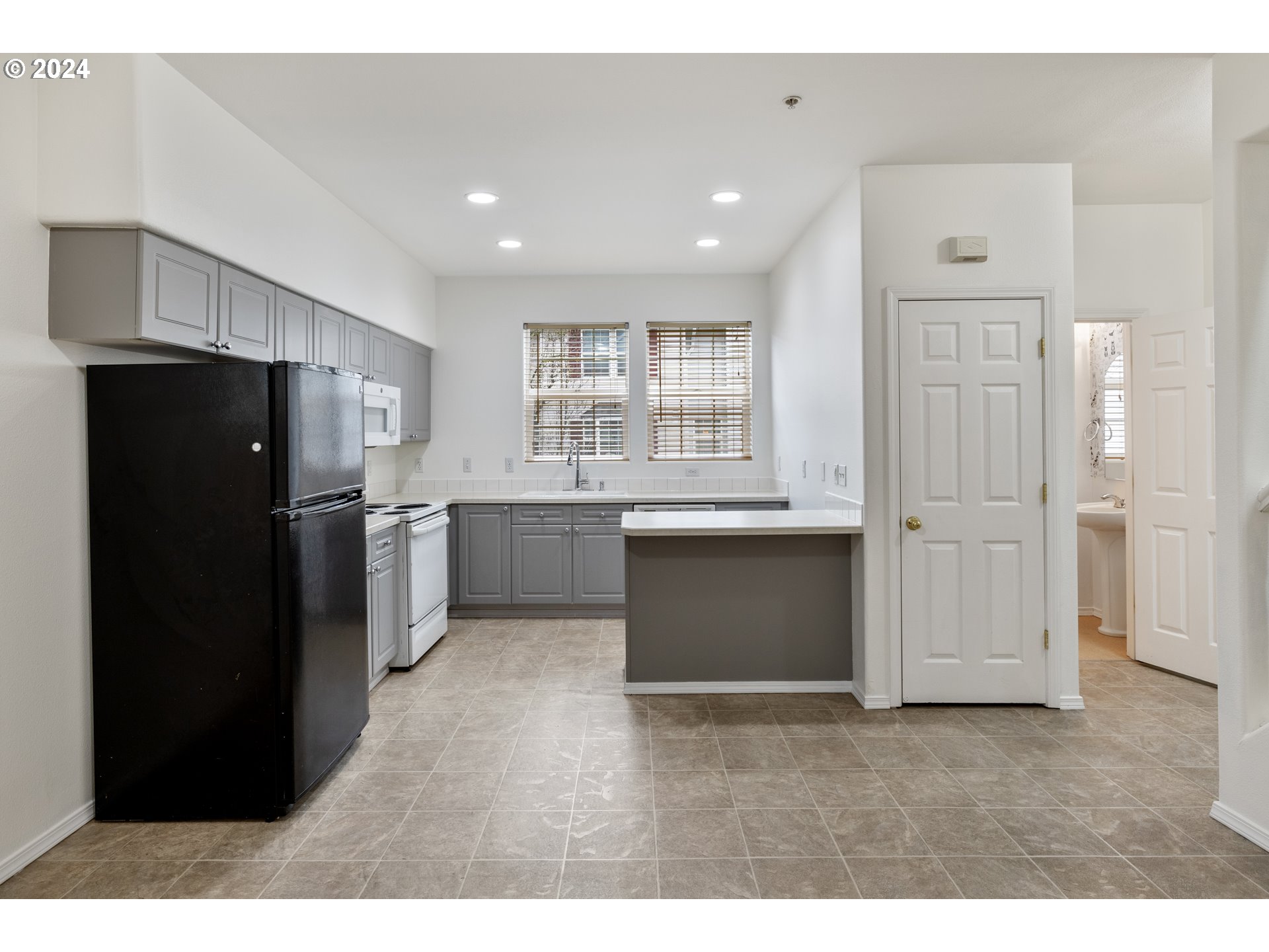 14340 Southwest Cougar Ridge Drive Beaverton, OR 97008 - Photo 6 of 37 a kitchen with a refrigerator and a sink