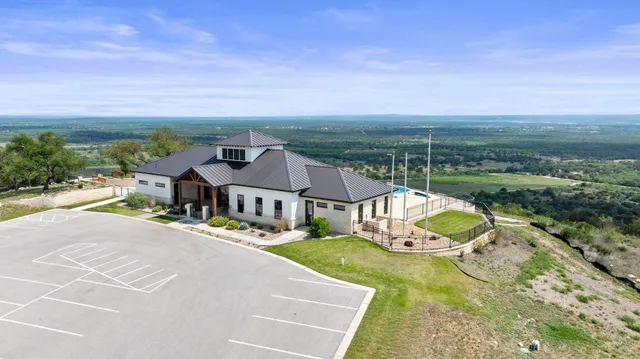 an aerial view of a house with swimming pool garden and lake view