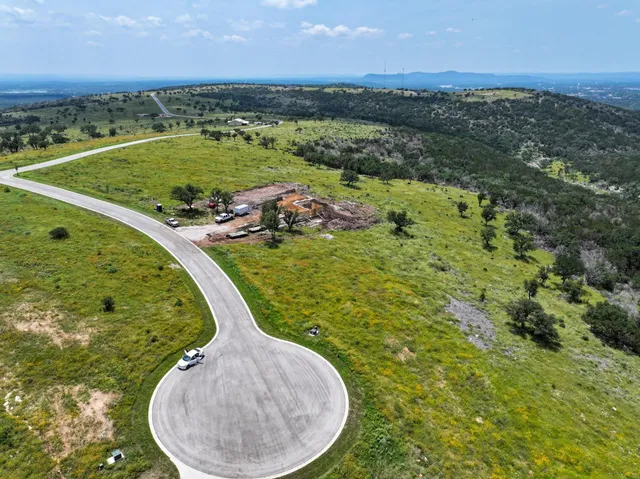 an aerial view of a swimming pool with a yard