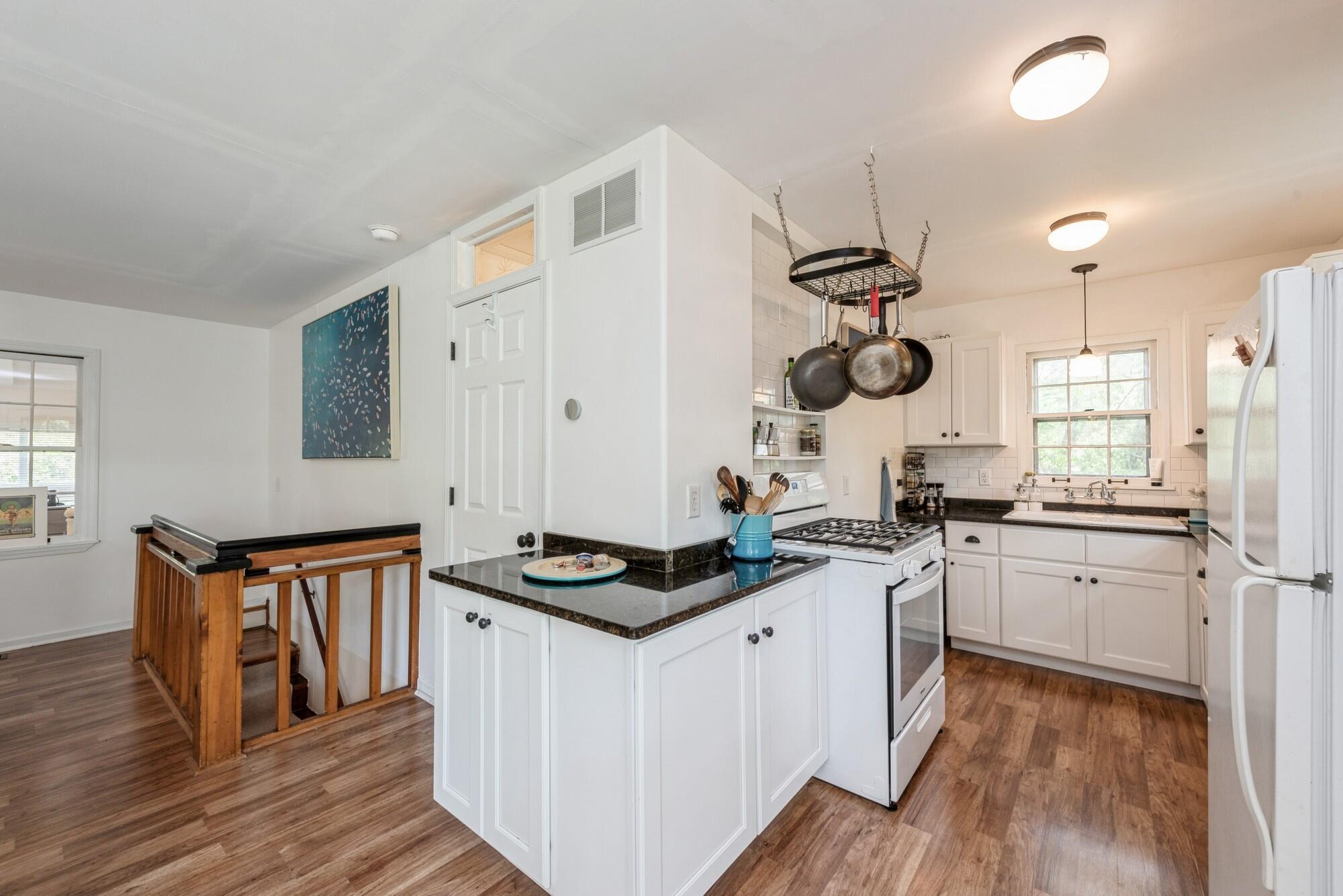 8 Turret Road Portage, IN 46368 - Photo 8 of 36 a kitchen with stainless steel appliances granite countertop a stove a sink dishwasher and white cabinets with wooden floor