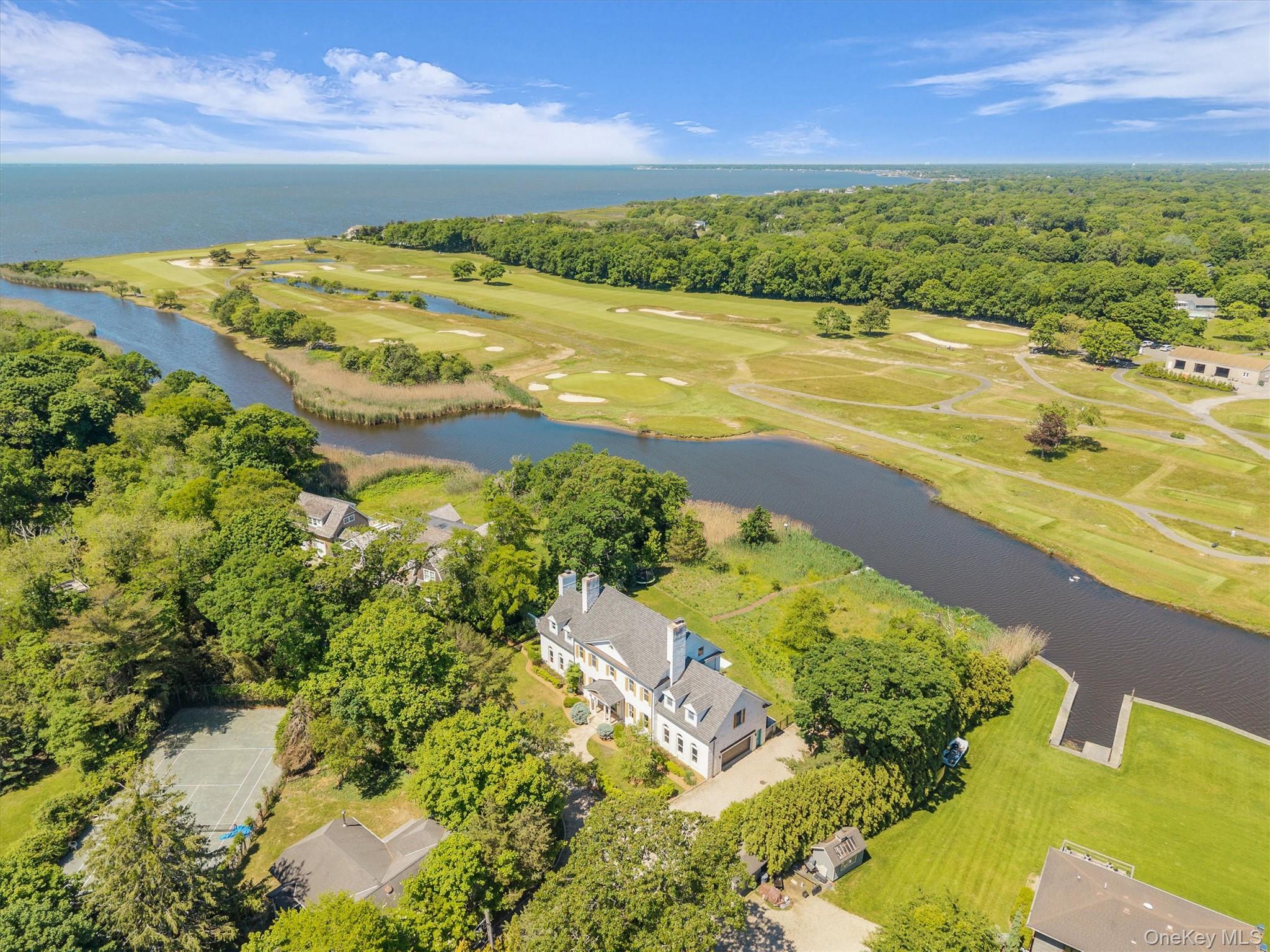 68 South Howells Point Road Bellport, NY 11713 - Photo 4 of 47 Waterfront property featuring a white multi-story residence with a pool, expansive lawn, and a private dock. Views of golf course and Bellport Bay
