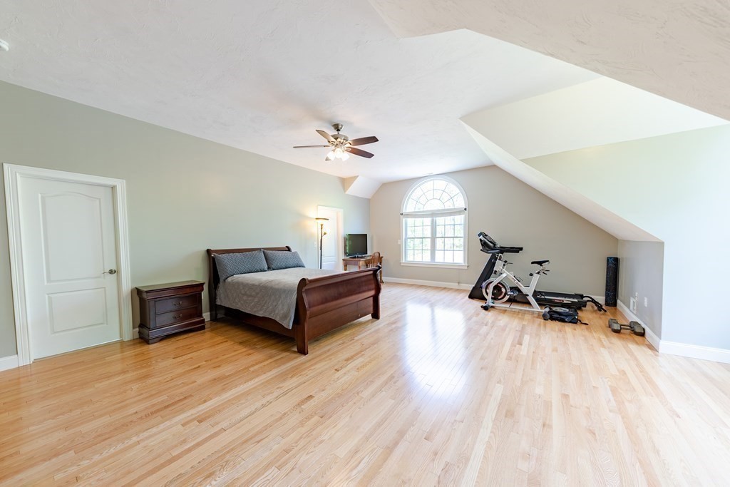 101 Stonefence Road Lunenburg, MA 01462 - Photo 36 of 41 a spacious bedroom with a bed a table and a chandelier
