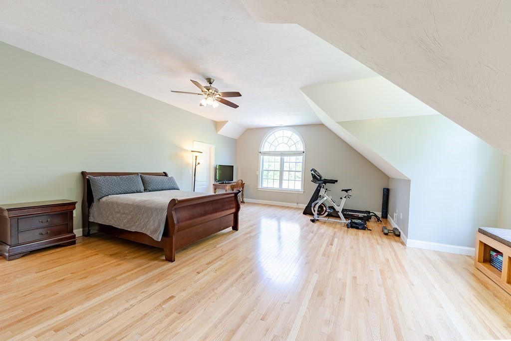 101 Stonefence Road Lunenburg, MA 01462 - Photo 37 of 41 a spacious bedroom with a bed a table and a potted plant