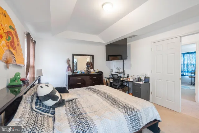 a bedroom with a bed a large window and dresser