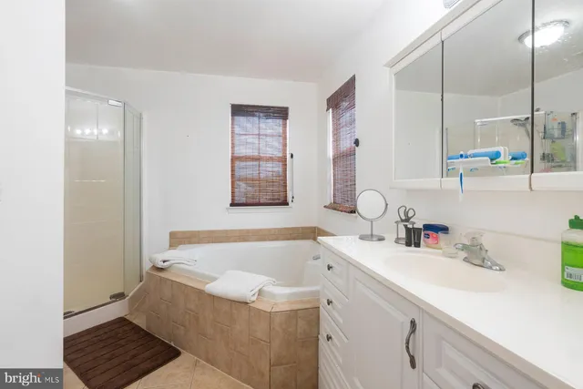a bathroom with a tub sink and mirror