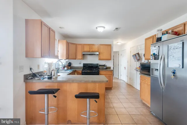 a kitchen with kitchen island a counter top space cabinets and stainless steel appliances