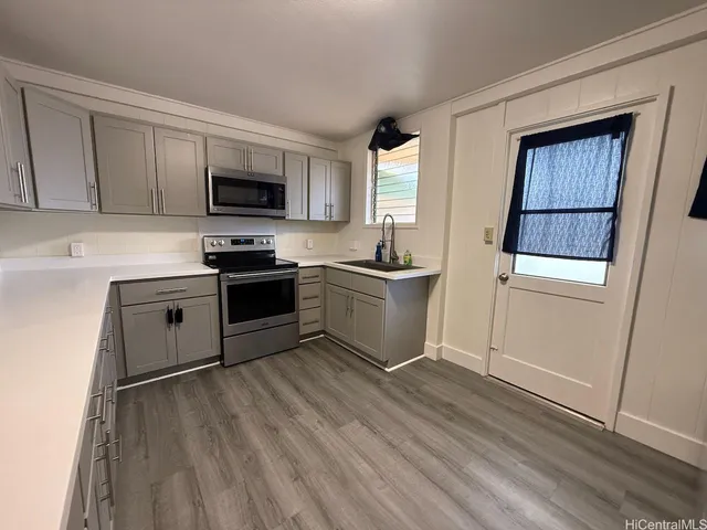 a kitchen with a sink cabinets and wooden floor