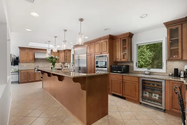 a large kitchen with stainless steel appliances lots of counter space and a sink
