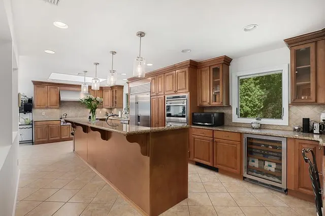 a large kitchen with stainless steel appliances lots of counter space and a sink