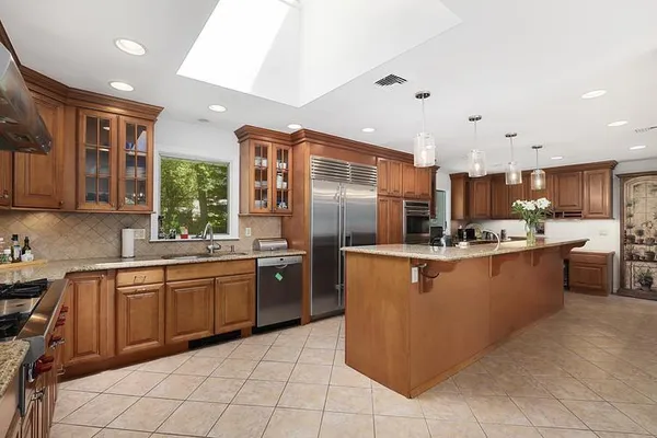a kitchen with stainless steel appliances granite countertop a sink counter space cabinets and a large window