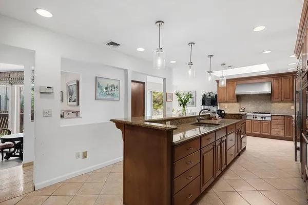 a large kitchen with stainless steel appliances granite countertop a stove and a refrigerator