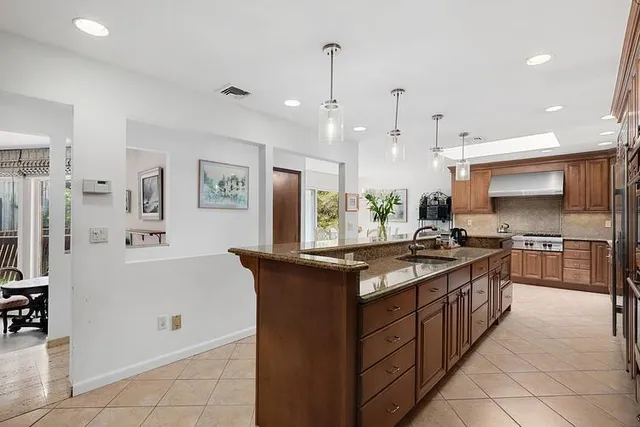 a large kitchen with stainless steel appliances granite countertop a stove and a refrigerator