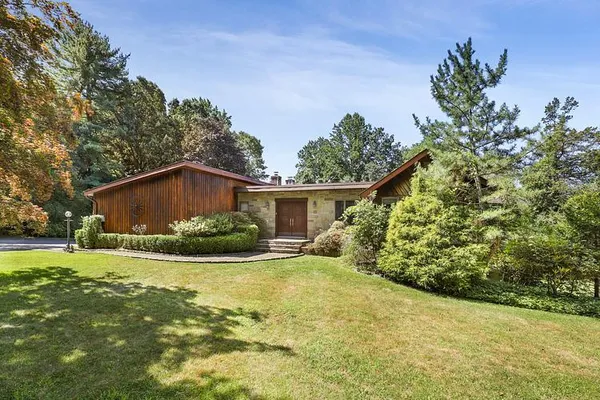 a view of a house with a yard and potted plants