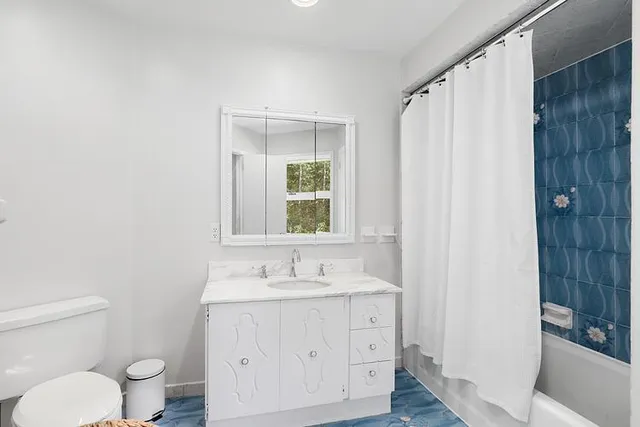 a bathroom with a granite countertop sink toilet and shower