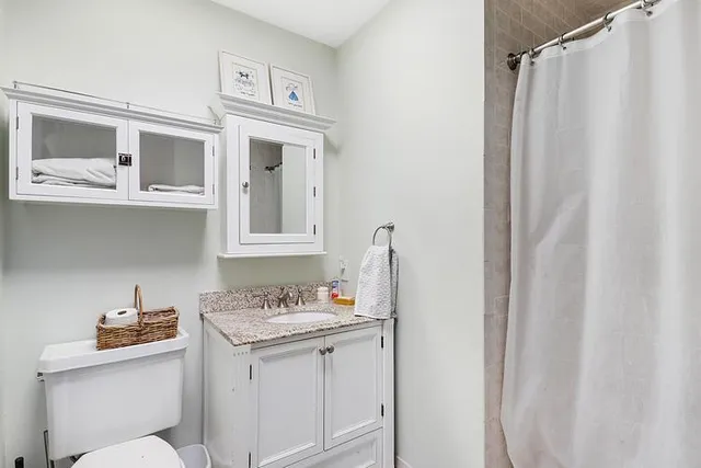 a bathroom with a granite countertop sink toilet and shower