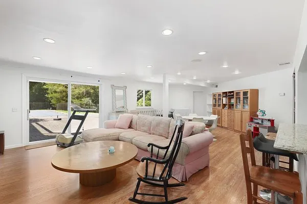 a living room with furniture a dining table and a window