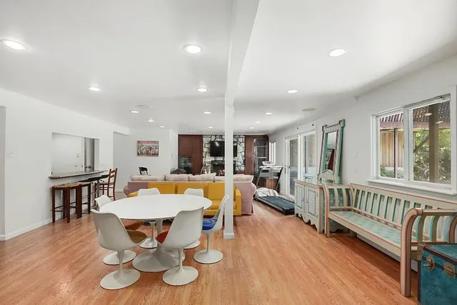 a view of a dining room with furniture a rug and wooden floor