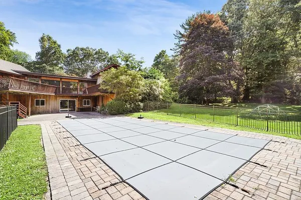 a view of a house with a yard and a large tree