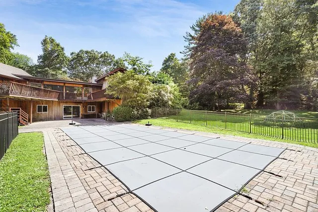 a view of a house with a yard and a large tree